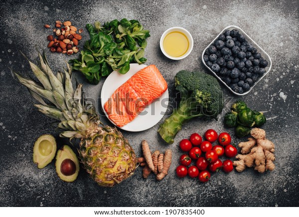Anti inflammatory diet concept. Set of foods that\
help to reduce inflammation - plant based ingredients, fresh fruit,\
green vegetables. Healthy diet products, top view, stone\
background. Toned