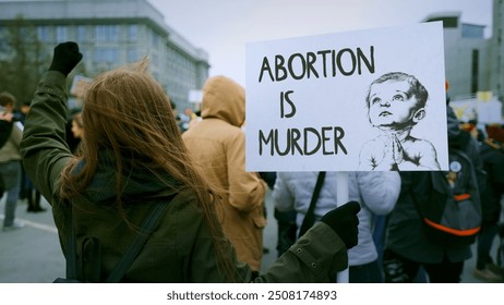 Anti murder demonstration city street. Stop abortion protest. Girl hold let baby live placard. Kill ban prohibition. Pro life banner. No roe v wade law. Angry women crowd Lot female people fight right - Powered by Shutterstock