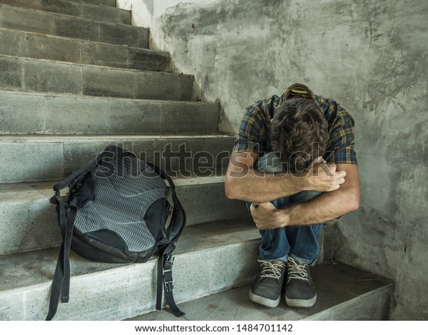 anti\
sexual discrimination and against homophobia campaign. Young sad\
and depressed college student man sitting on staircase desperate\
victim of harassment suffering bullying and abuse\
