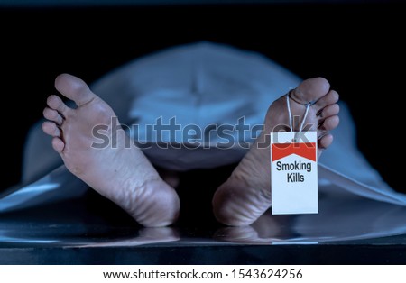 Anti smoking advertising design image. Dead body at morgue with toe tag with text Smoking kills written on it. Social awareness campaign Say NO to Tobacco and health effects of cigarette smoking.