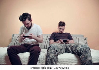 Anti Social Behavior , Young Adult Male And Teen Staring In Smartphone 