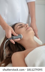 Anti-age. Dark-haired Woman Having Laser Face Treatment In Clinic