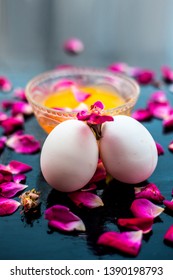 Anti-aging Face Pack I.e.  Milk And Egg Face Pack In A Glass Bowl On Shiny Black Surface With Some Rose Petals And Entire Of Its Constituents With It.