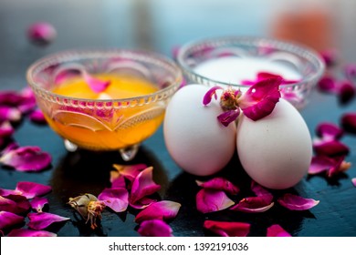 Anti-aging Face Pack I.e.  Milk And Egg Face Pack In A Glass Bowl On Shiny Black Surface With Some Rose Petals And Entire Of Its Constituents With It.