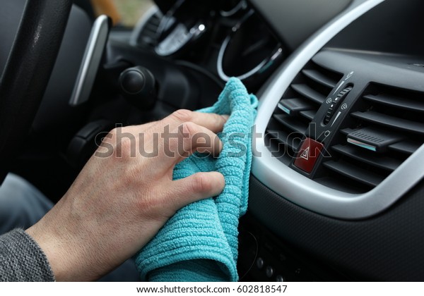 Antibacterial car\
cleaning. Coronavirus Prevention. Hand with microfiber cloth\
cleaning car interior close\
up