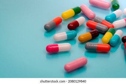 Antibiotic capsule pills on blue background. Prescription drugs. Colorful capsule pills. Antibiotic drug resistance concept. Pharmaceutical industry. Superbug problems. Medicament and pharmacology. - Shutterstock ID 2080129840