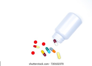 Antibiotic capsules spilling out of pill bottle isolated on white background with clipping path. Antibiotic drug use with reasonable concept. Health policy and health insurance concept