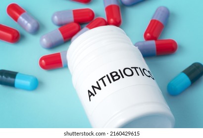Antibiotic Medicine Concept, Antibiotics Bottle With Pills Spilled Out, Closeup On Blue Background
