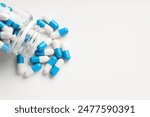 Antibiotic pills and bottle on white background, top view. Space for text