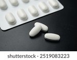 Antibiotic pills Medicine tablet capsules in blister pack on a black background