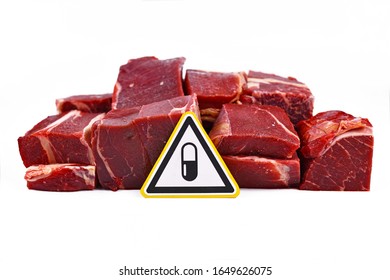 Antibiotics Residue And Harmful Bacteria In Meat For Human Consumption Concept, Showing Chunks Of Red Meat With Yellow Warning Sign With Pill