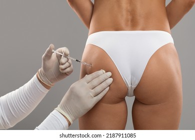 Anti-Cellulite Care. Young Woman In Underwear Having Lipolysis Treatment At Beauty Salon, Unrecognizable Beautician In Gloves Making Injection Shot To Female Buttocks With Smooth Skin, Closeup