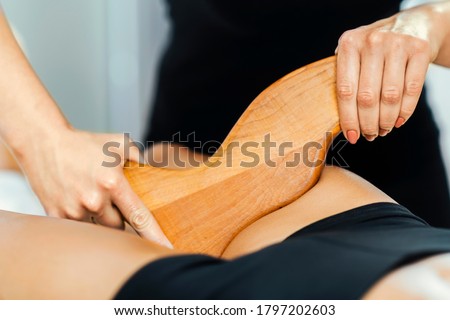 Anti-Cellulite Madero Therapy Thigh Treatment. Female Masseuse Performing Cellulite Reduction Treatment