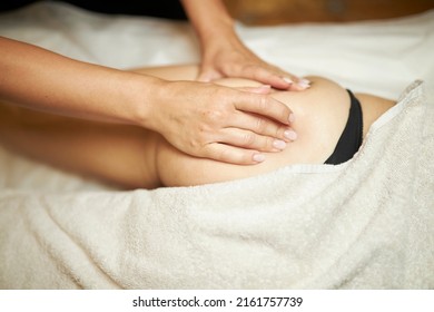 Anti-cellulite Massage Of The Buttocks, The Masseur's Hands Massage The Buttocks Of The Patient. The Masseur Makes An Anti-cellulite Massage Of The Buttocks To A Woman.