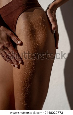 Anti-cellulite wrapping procedure with scrub, close up plan of buttocks and legs
