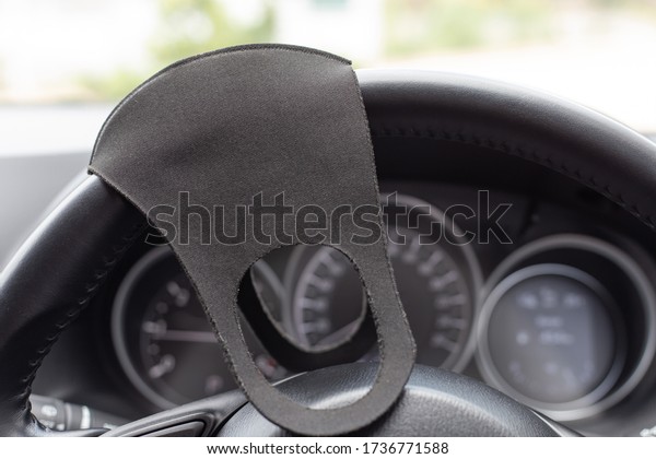 Anti-dust black face mask on steering wheel in\
vehicle interior.