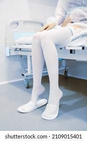 Anti-embolic surgery compression hosiery. Operating room in a hospital. Surgical equipment with operating table. Medical device for emergency patient in blue tone style. Clinic interior background.