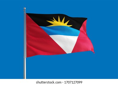 Antigua and Barbuda national flag waving in the wind on a deep blue sky. High quality fabric. International relations concept.