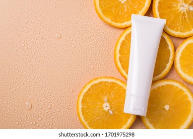 Antioxidant Lifestyle Wellness Branding Concept. Top Above Flatlay Flat Lay Overhead Close Up View Photo Of Blank Cream Tube Lying On Slices Of Orange Fruit Isolated Beige Background Copy Empty Space