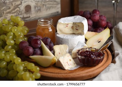 Antipasti.    Cheese camembert with grapes, sliced pears and confiture, a great appetizer for wine. - Shutterstock ID 1799656777