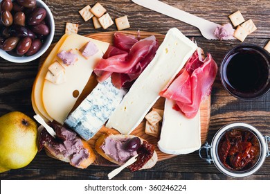 Antipasti Platter With Different Meat And Cheese Products On  Wooden Board. Top View