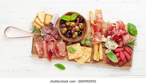 Antipasto Board With Prosciutto, Salami, Crackers, Cheese And Olives. Top View Flat Lay