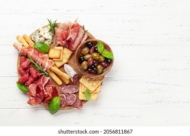 Antipasto board with prosciutto, salami, crackers, cheese and olives. Top view flat lay with copy space - Powered by Shutterstock