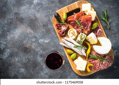 Antipasto Board With Sliced Meat, Ham, Salami, Cheese, Olives And Red Wine. Top View With Copy Space.