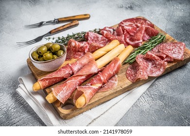 Antipasto platter cold meat plate with grissini bread sticks, Prosciutto crudo, Salami and Coppa Sausage. White background. Top view.