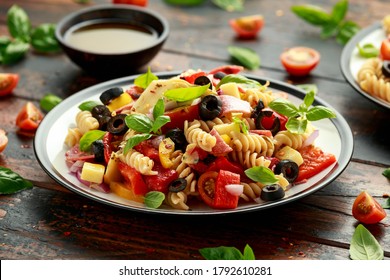 Antipasto Salad With Pasta, Tomato, Olives, Red Onion, Bell Pepper, Salami, Cheese, Artichoke And Basil.