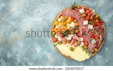 Antipasto with traditional Spanish meat snacks on a slate board, Antipasto platter. catering, banner, menu, recipe. place for text, top view.