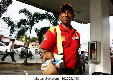 Antipolo City, Philippines - January 10, 2020: Worker At A Gas Refilling Station Gives A Customer His Change And His Loyalty Card After Refueling.