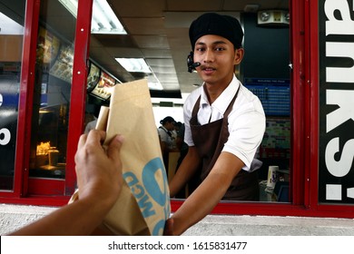 Antipolo City, Philippines - January 11, 2020: Worker At A Fast Food Restaurant Give The Food Order Of A Customer At A Drive Thru Window.