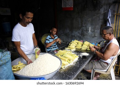 Antipolo City, Philippines - January 29, 2020: Workers prepare to cook Suman or steamed glutenous rice wrapped in palm tree leaves.
