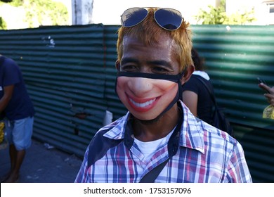 Antipolo City, Philippines - June 6, 2020: Adult Filipino Man Use A Washable Face Mask With A Funny Face Printed On It During The Covid 19 Virus Outbreak.