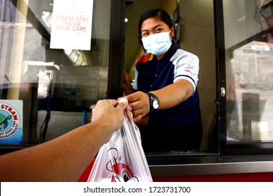 Antipolo City, Philippines - May 5, 2020: Employee Of A Fast Food Restaurant Give A Customer's Order At The Drive Thru Window During The Covid 19 Virus Outbreak.