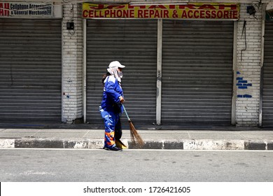 Antipolo City, Philippines - May 7, 2020: Street Cleaner Sweeps In Front Of Closed Commercial Establishments During The Lock Down Due To Covid 19 Virus Outbreak.