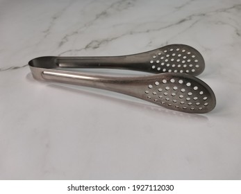 Antipolo, Philippines - February 2021: Selective focus serving kitchen tongs on white background.