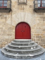 Antique Arched Double Doors. Wooden Red Entrance Doors In Stone Building. Stone Steps Staircase Porch In Front Of Entrance. Vertical Frame.