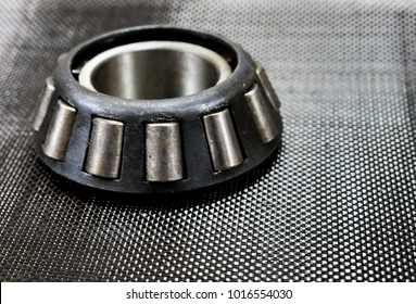 Antique Automotive Tapered Roller Bearing On Plain Weave Carbon Fiber.