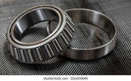 Antique Automotive Tapered Roller Bearing And Race On Plain Weave Carbon Fiber Cloth.