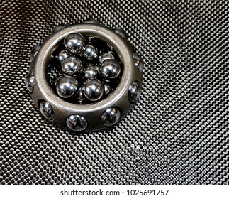 Antique Automotive Vintage Wheel Bearing With Loose Ball Bearings On Plain Weave Carbon Fiber