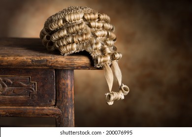 Antique barrister's wig lying on an old wooden desk