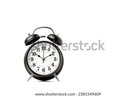Antique black alarm clock with white dial. isolated on a white background.