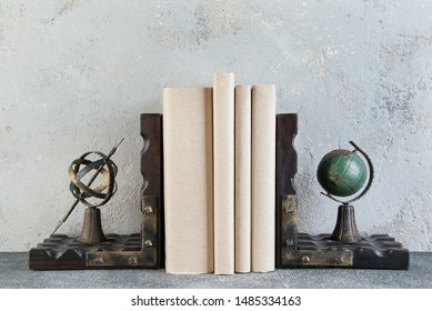 Antique Book Ends And Books On Table On Gray Background