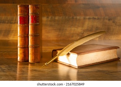 Antique books on a wooden background and a nib, concept of learning never gets old