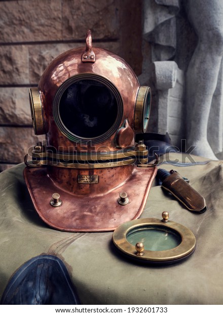Antique, brass\
diving helmet and old knife on a diving suit. Translation: Soviet\
Union, helmet N 321 1986\
year
