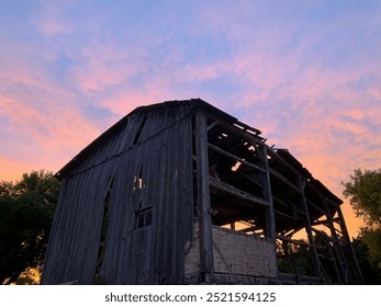 Antique burnt down barn at sunset