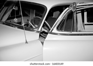 Antique Car From The 50s With The Driver's Side Door Ajar Photographed In Black And White.