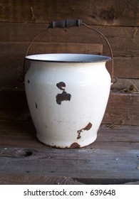 Antique Chamber-pot against a barn wall.